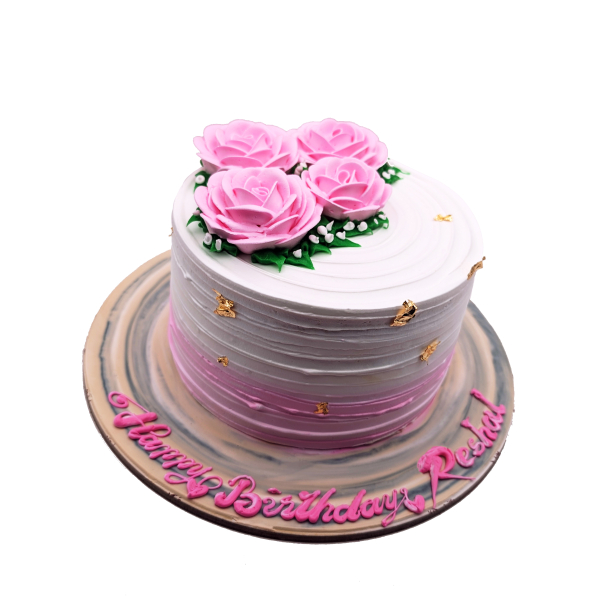 Round two-layer mango cake topped with pink buttercream roses, gold leaf accents, and “Happy Birthday Reshal” written in pink on a gold cake board