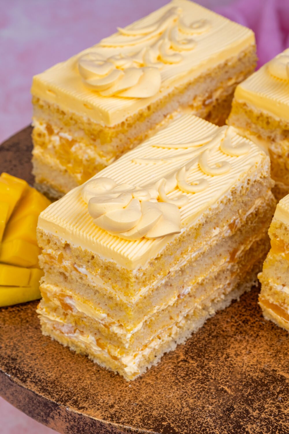 Mango Pastry Mango pastry slice with layered vanilla sponge and mango cream frosting