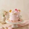 Pink blush floral celebration cake with gold leaf accents and elegant rose decoration